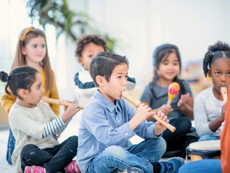 Children playing recorders and percussion instruments together
